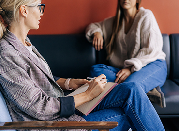 The psychologist makes a social survey of the reference group. A professional is talking to a client. Informal communication at the interview, business consultant writes notes in a notebook.